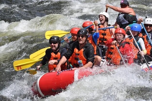 People rowing over rapids