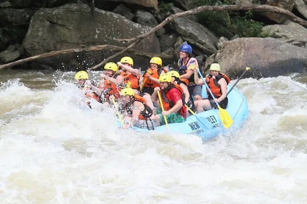 People rowing over rapids