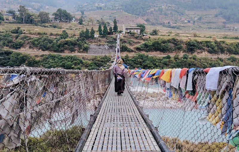 A woman walking on the Punakha Suspension Bridge, Punakha, Bhutan