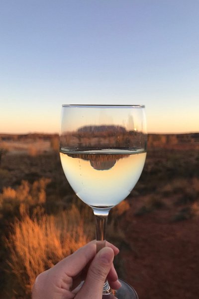Glass of champagne with Uluru in the background at Sounds of Silence