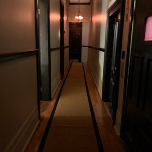 Hallway pic taken during the day where a hotel room's door is open for cleaning. Lets just enough light in to take a picture. You can see the "runner" on the floor and how it is buckled and not affixed to the floor. Can you imagine how dark it is in here at night?
