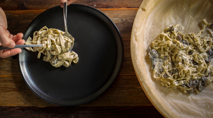Tagliolini pasta, simple mushroom-and-cream sauce, finished off in a wheel of Parmigiano Reggiano