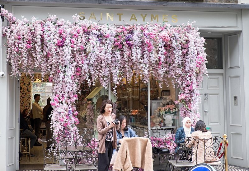 Storefront of Saint Aymes cafe in London, with pink florals