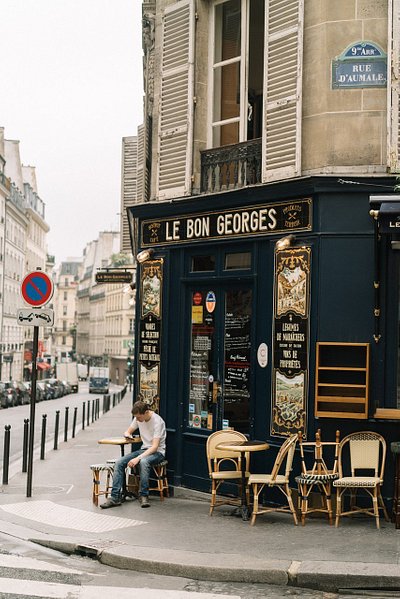 A man sitting outside Le Bon Georges bistro in Paris