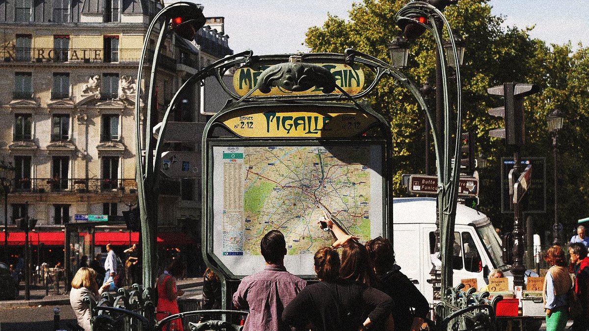 A group of travelers checking out the metro map at Pigalle Metro Station in Paris