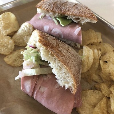 Italian sub and potato chips on a metal tray