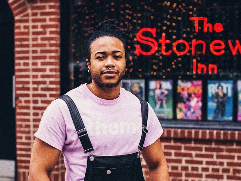A photo of a person standing in front of The Stonewall Inn