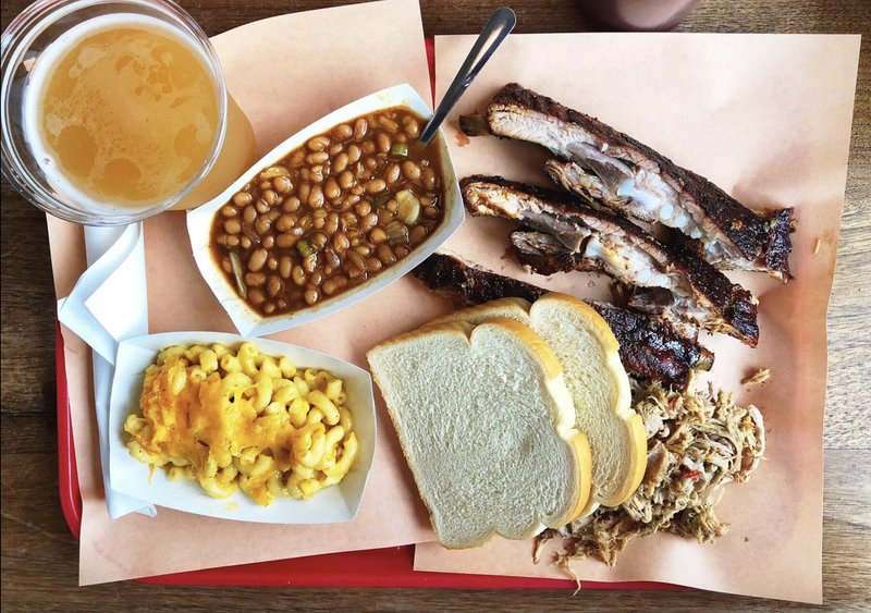 A plate of smoked ribs, pulled pork, macaroni and cheese and baked beans.