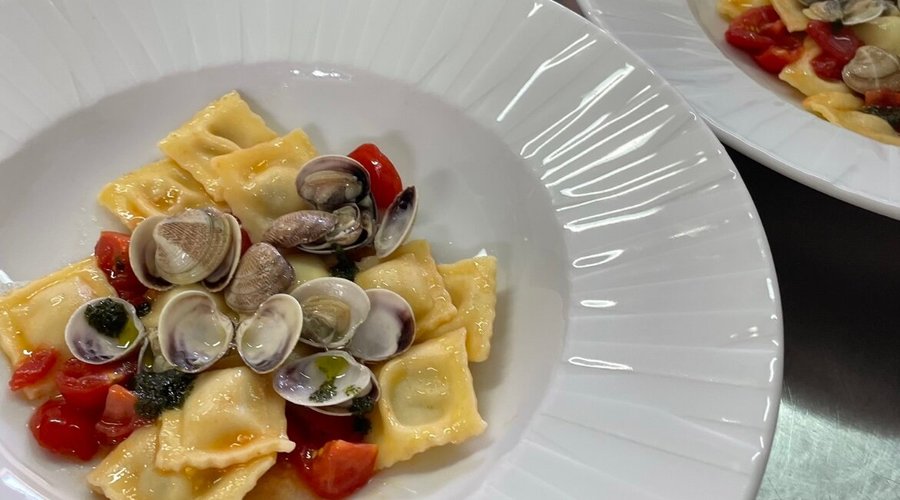 Ravioli Ripieni di spigola al profumo di limone con pomodorini, vongole e pesto di basilico

