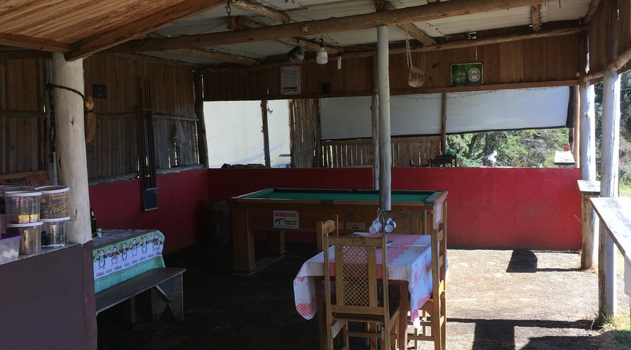 Espaço interno com mesas e bar.