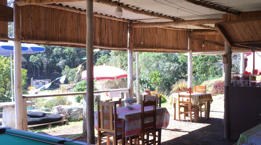 Espaço interno com mesas e bar.