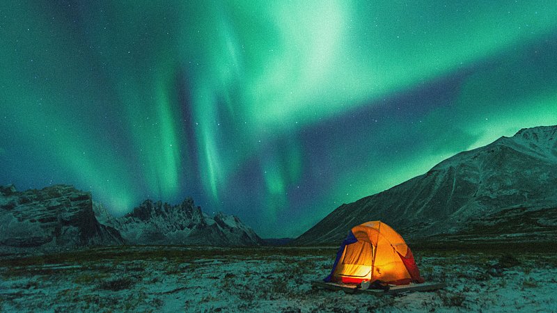 Aurora boreal com uma tenda com neve no Yukon, Canadá