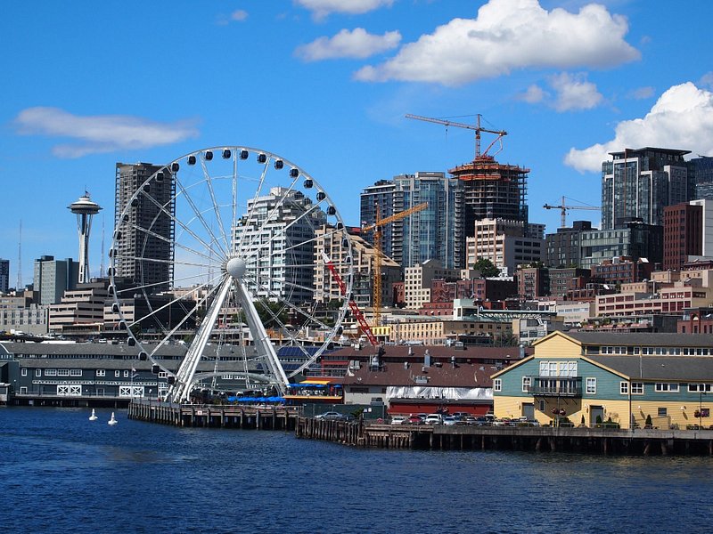 The Seattle skyline on a blue sky day, including the Great Wheel and Space Needle