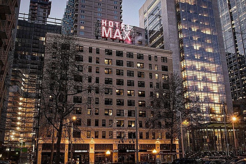 The outside of a ten story building with "Hotel Max" lit up in red at the top