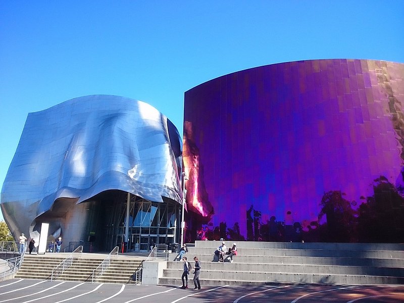 Two large, reflective, wave-shaped buildings signal the entrance to the Museum of Pop Culture