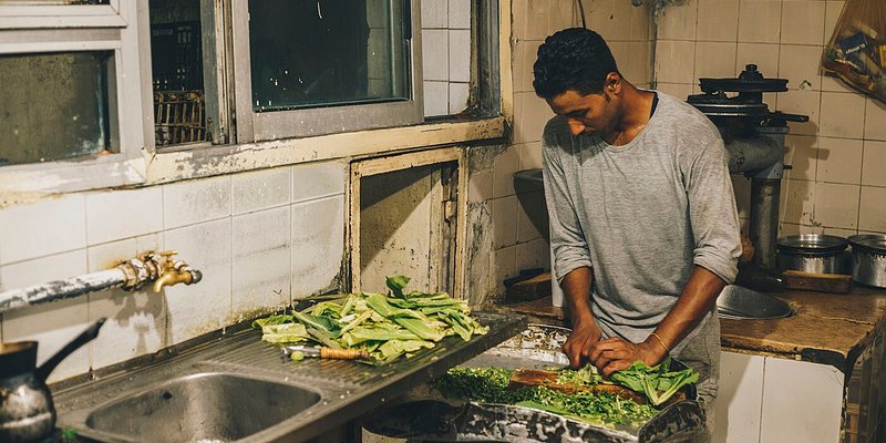 A man prepares Egyptian food in a kitchen.