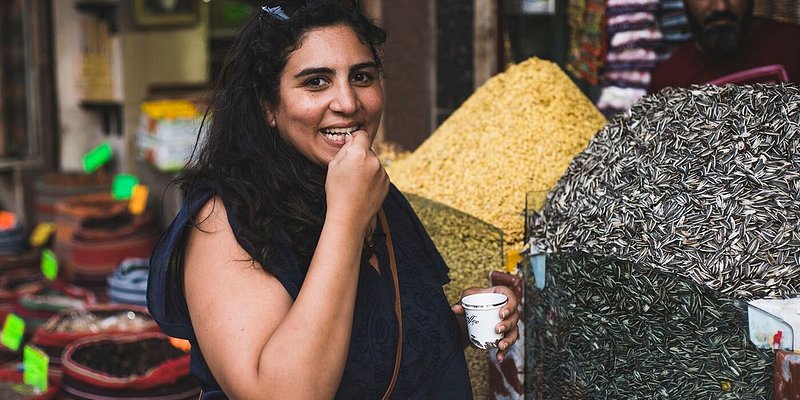 A woman tries a snack on a Cairo food tour