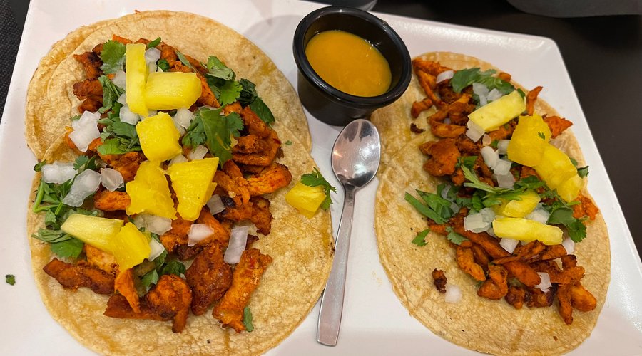Taco al pastor.  Cada taco con 2 tortillas de maíz , lomo de cerdo “al pastor”, acompañado de piña, cebolla y cilantro acompañados de una salsa especial de la casa. ¡Estupendos!