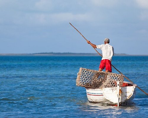 Mauritius, a man fishing wearing a motorbike helmet as hat at Belle Mare  beach, Stock Photo, Picture And Rights Managed Image. Pic. U22-1875257