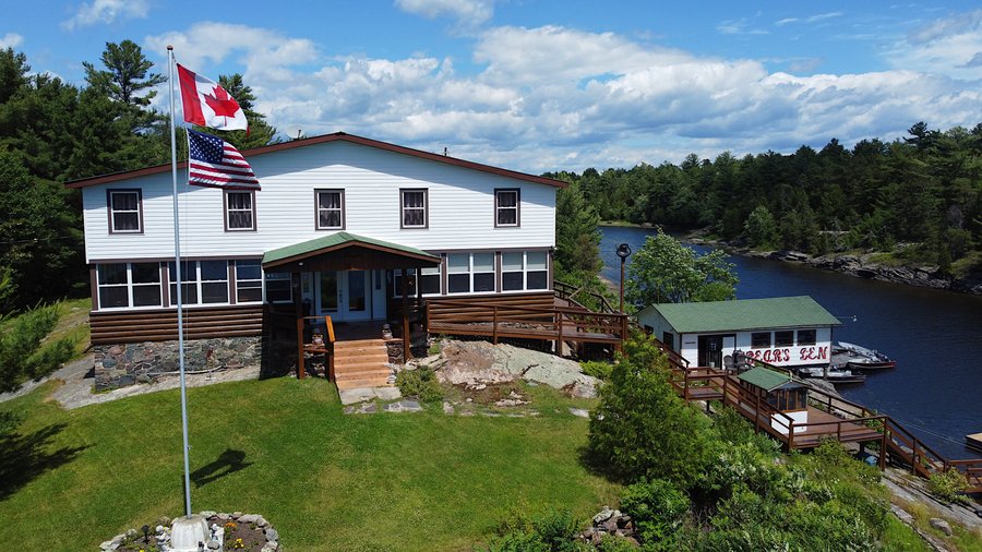 Photo of the Main Lodge of the Bear's Den property along with the boat house.