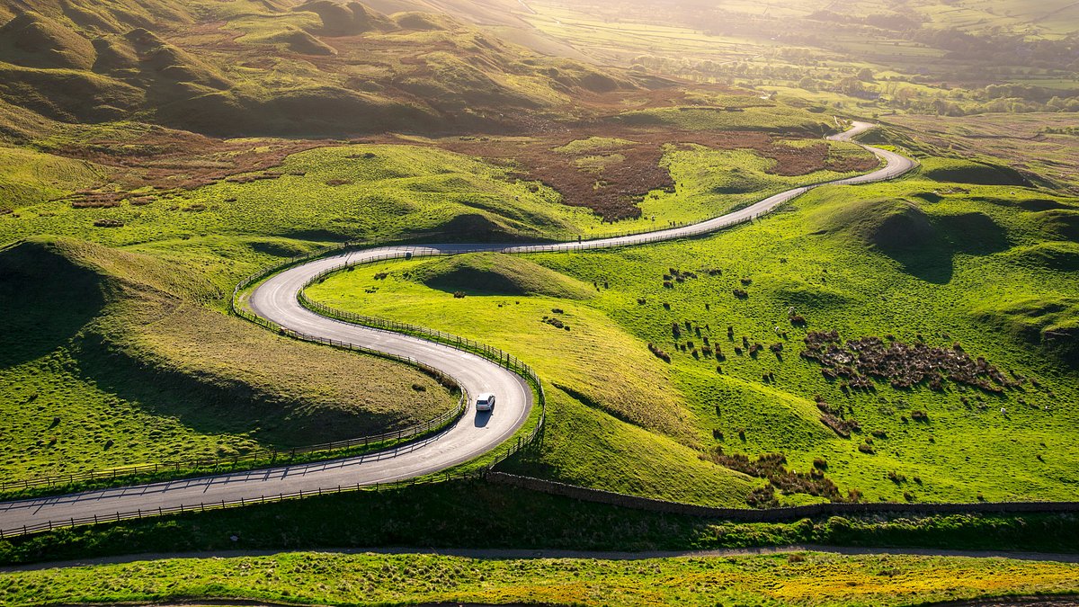Winding road cutting through green landscape
