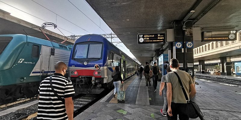 People walking towards a train at Stazione Roma Termini