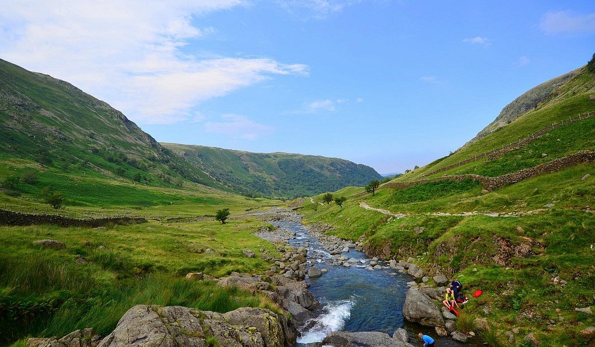People walking by a stream in Lake District in England