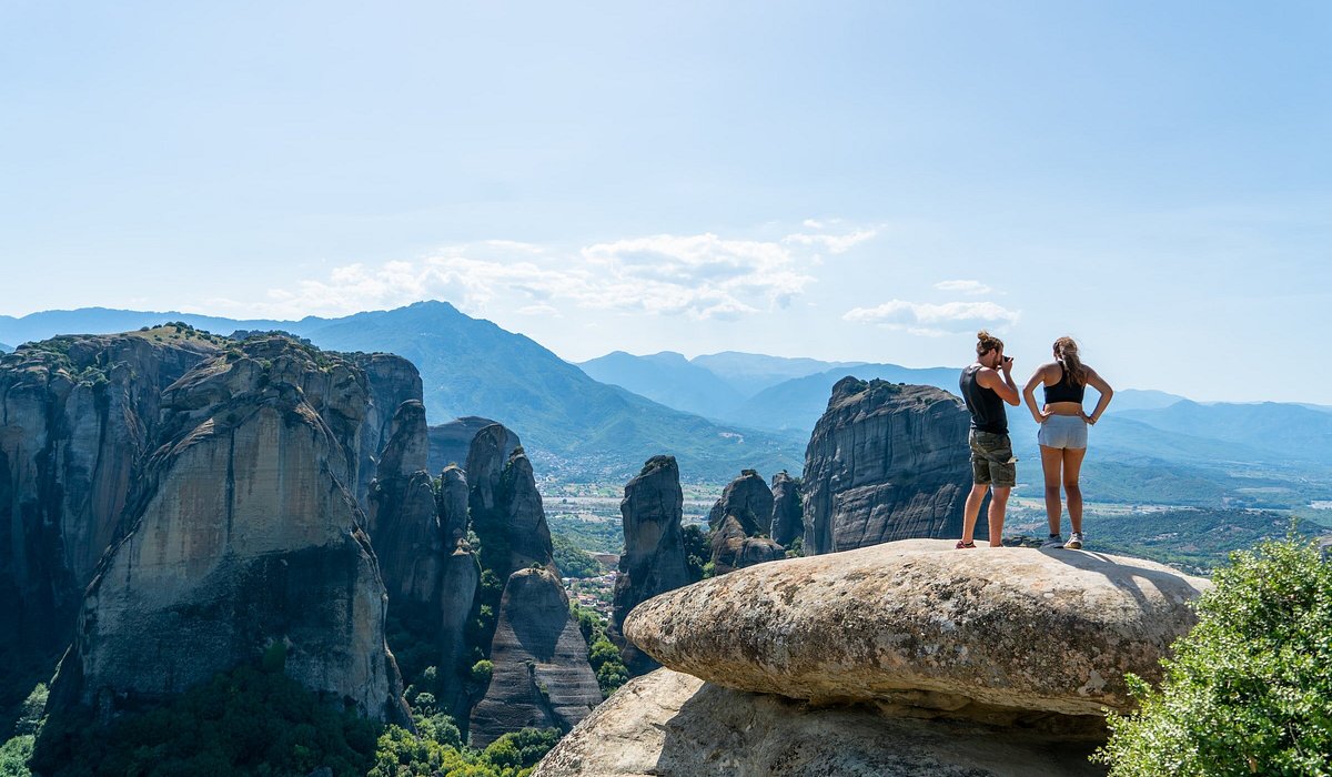 A couple standing on a rock at Meteora, Greece