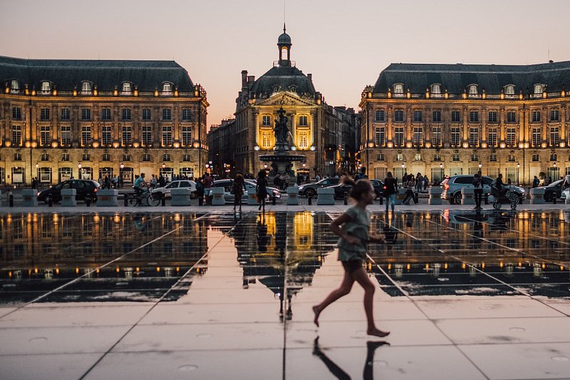 A girl running across the water mirror in Bordeaux France