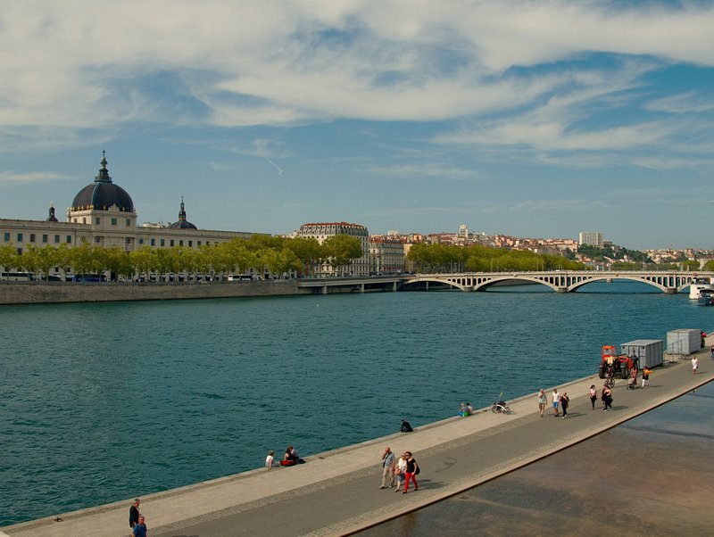 Reisende, die in Lyon an einem Fluss spazieren