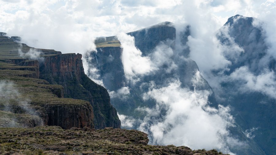 The Drakensberg Amphitheatre is engulfed by clouds in the afternoon. Tugela Falls can be seen in the distance, with Sentinel Peak in the top right corner.