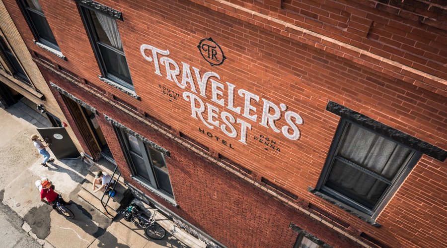 Guests share a moment in front of our hotel. Featuring the sign painting work of Anthony Purcell.