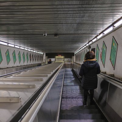 A woman going down the escalator at a Rome Metro station