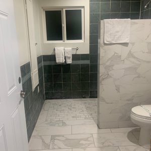 Huge walk-in shower. Bright, clean and the little door on the left wall near the window is a drop down ironing board.