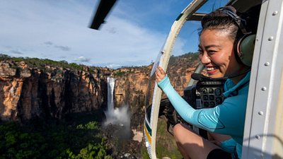A woman looking out of a helicopter flying over Kakadu National Park