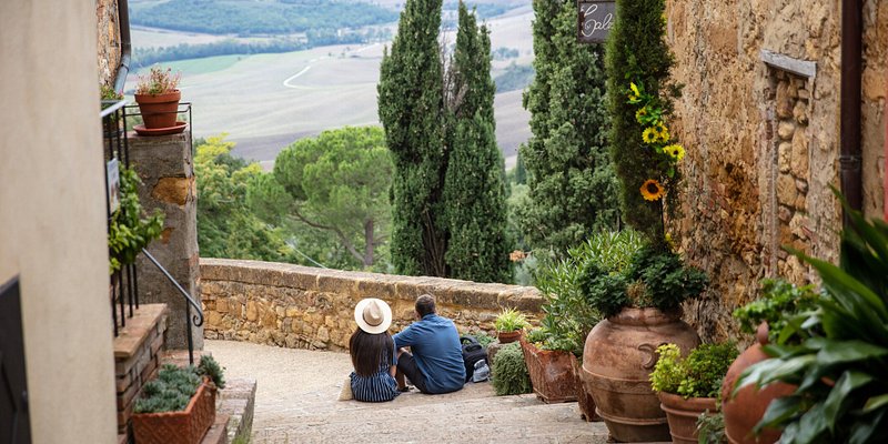 Rear view of a couple sitting on the stairs, Pienza, Italy