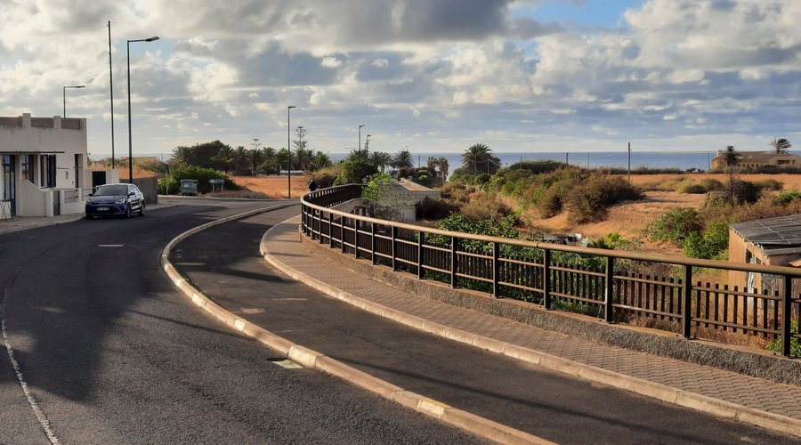 Acesso com parque de estacionamento e praia ao fundo