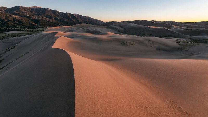 Dunas de areia ao pôr do sol no Parque Nacional e Reserva de Great Sand Dunes, CO 