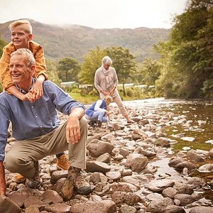 Grandparents explore the banks of the river Eachaig with their grandchildren at Stratheck