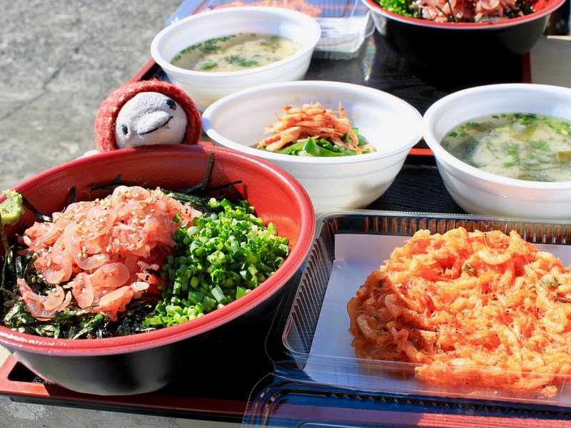 A tray of Japanese sashimi don and other side dishes including seaweed soup