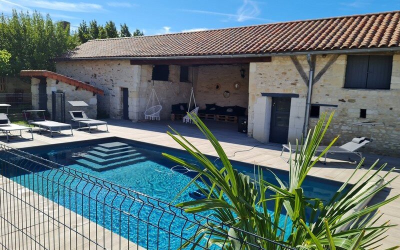 Vue sur la piscine et le salon abrité.