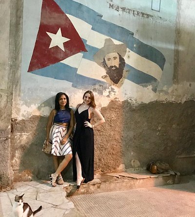 Two people standing next to mural at night