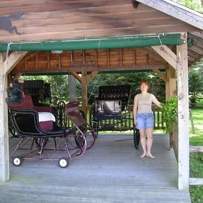 Trish Barney standing under open-air structure with old carriages