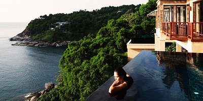 A woman relaxes by the edge of an infinity pool at the Paresa Resort in Phuket