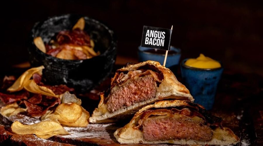 Saboroso hambúrguer de Angus (180g), queijo meia cura e bacon. Acompanha batatas chips, rúcula e tomate confitado, maionese da casa e ketchup da casa. 