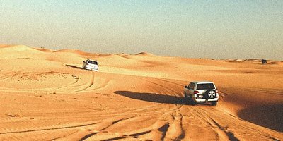 Twee 4WD-voertuigen rijden door Rub al Khali in Dubai, 's werelds grootste zandwoestijn