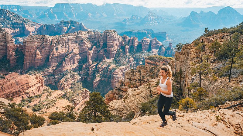 Woman trail running on Bear Mountain in Sedona, Arizona 