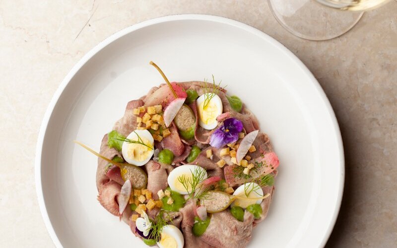 Lingua in salsa al prezzemolo, láminas tibias de lengua de 
vacuno con salsa cremosa de perejil, huevo de codorniz, 
alcaparras y crocante de pan