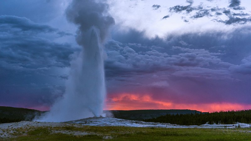 Erupção do Old Faithful ao pôr do sol, no Parque Nacional de Yellowstone