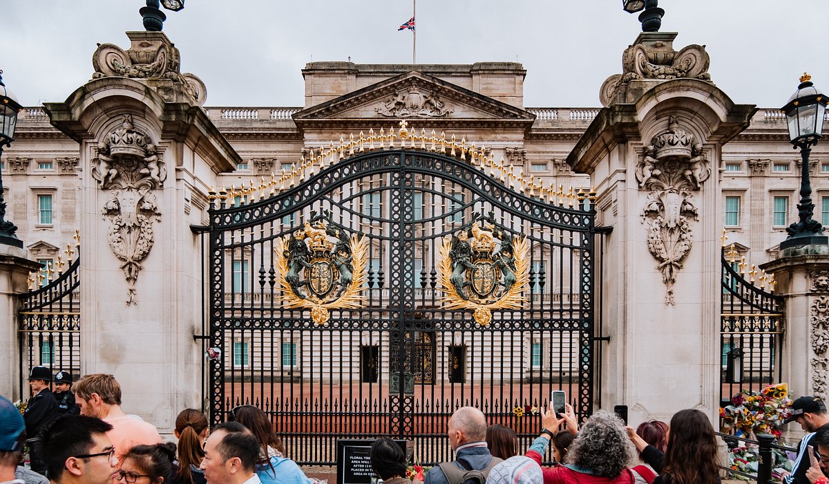 People taking photographs of the entrance of Buckingham Palace